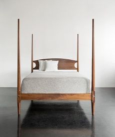 a bed room with a wooden frame and white sheets on the top, next to a black floor