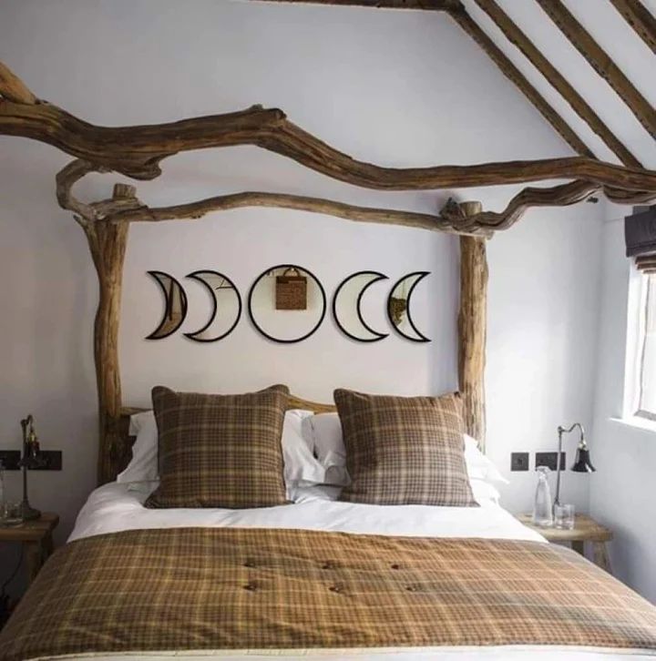 a bed with four pillows and three moon phases on the wall above it in a bedroom