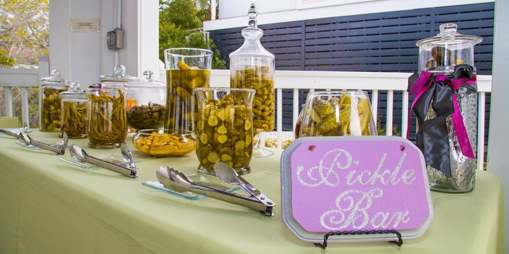 the table is set up with jars and spoons for pickle bar, which includes pickles