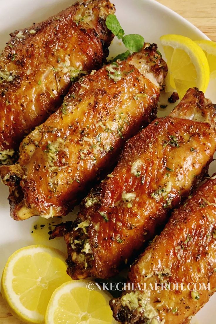 chicken wings with herbs and lemons on a plate