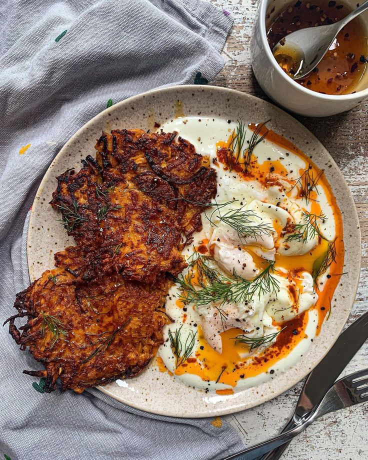 a plate with some food on top of it next to a bowl of sauce and spoon