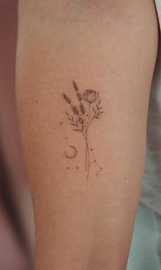 a woman's arm with a flower and moon tattoo on the back of her left arm