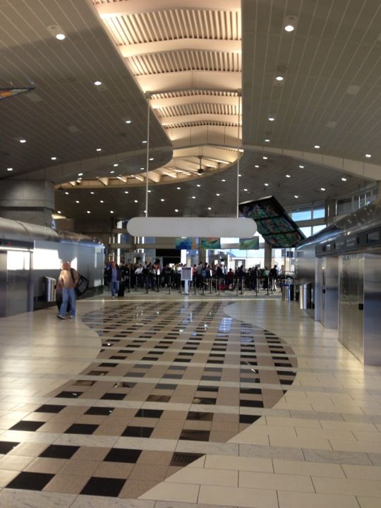 an airport lobby with people walking around