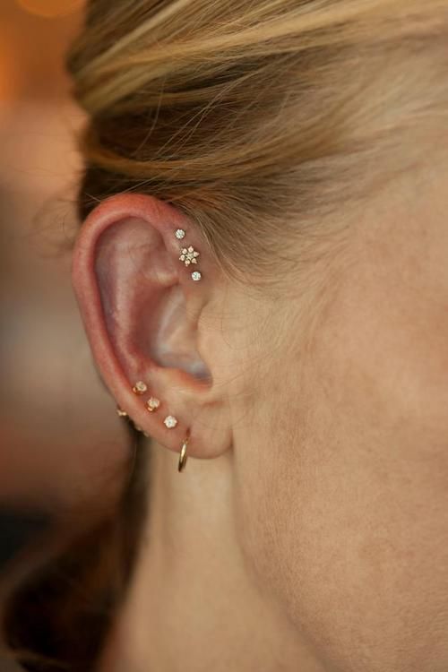 a close up of a person with ear piercings on their ears and behind the ear