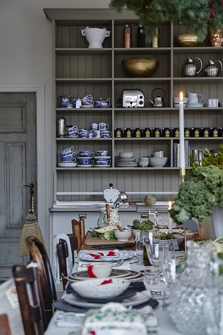 a dining room table is set with plates and silverware, candles in the center