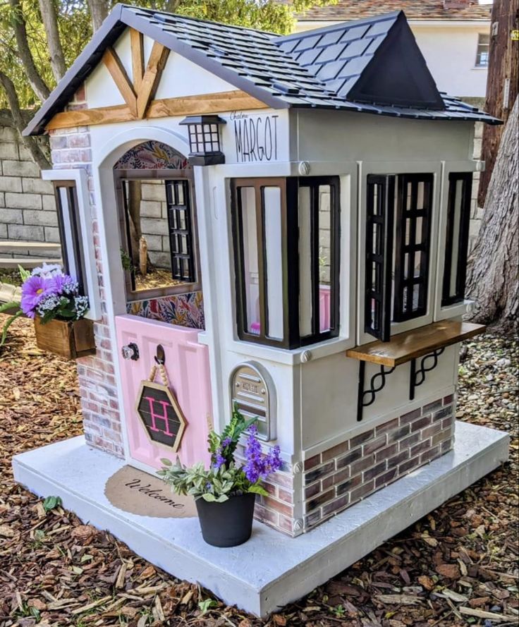 a doll house made out of cardboard with windows and shutters on the front door