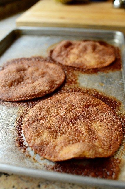 four fried food items on a baking sheet ready to be cooked in the oven,