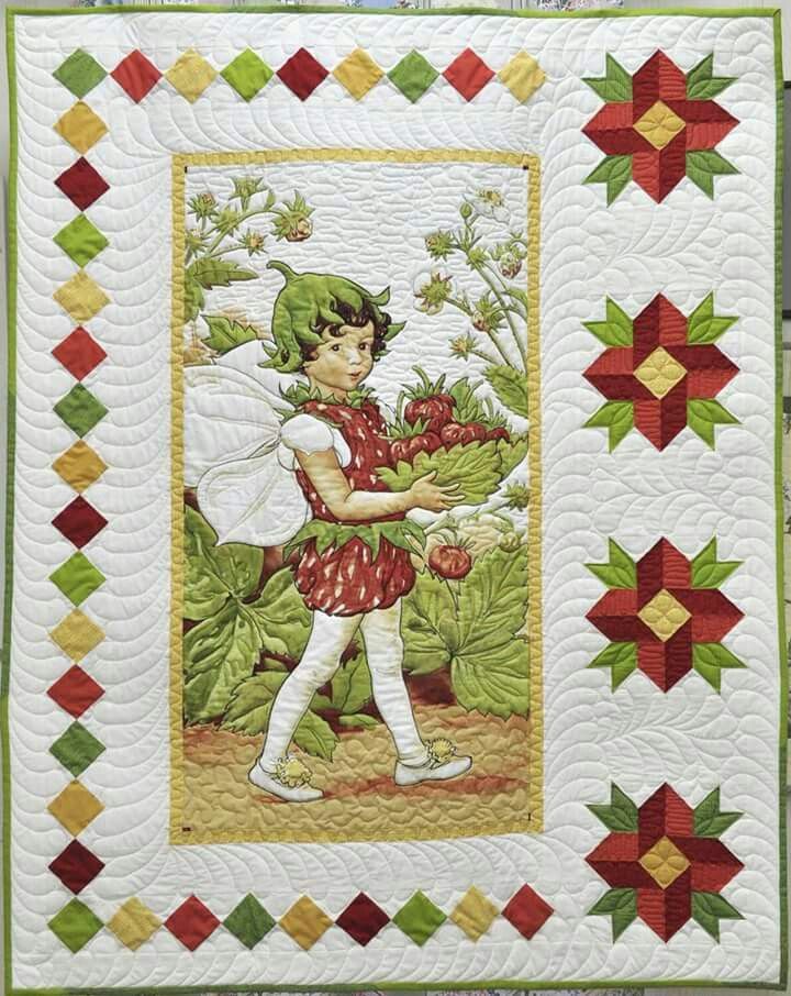 a child holding flowers on top of a green and red quilted wallhanger