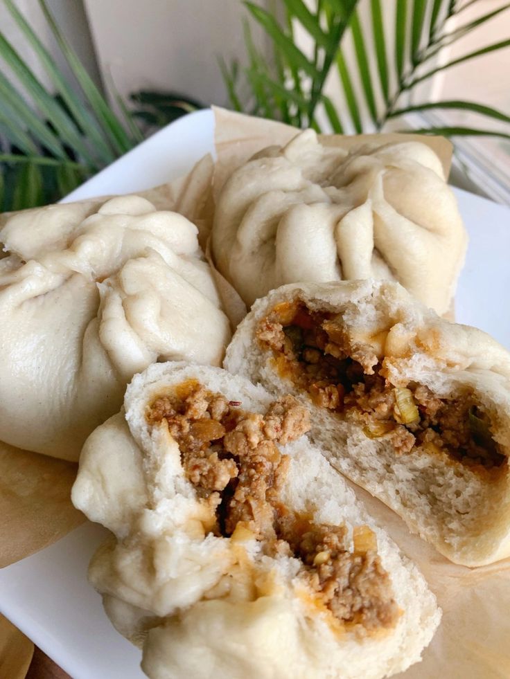 three dumplings on a plate with one cut in half