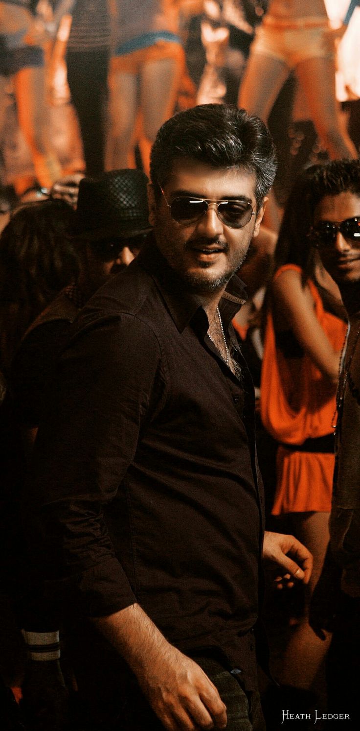 a man standing in front of a group of people wearing sun glasses and black clothing