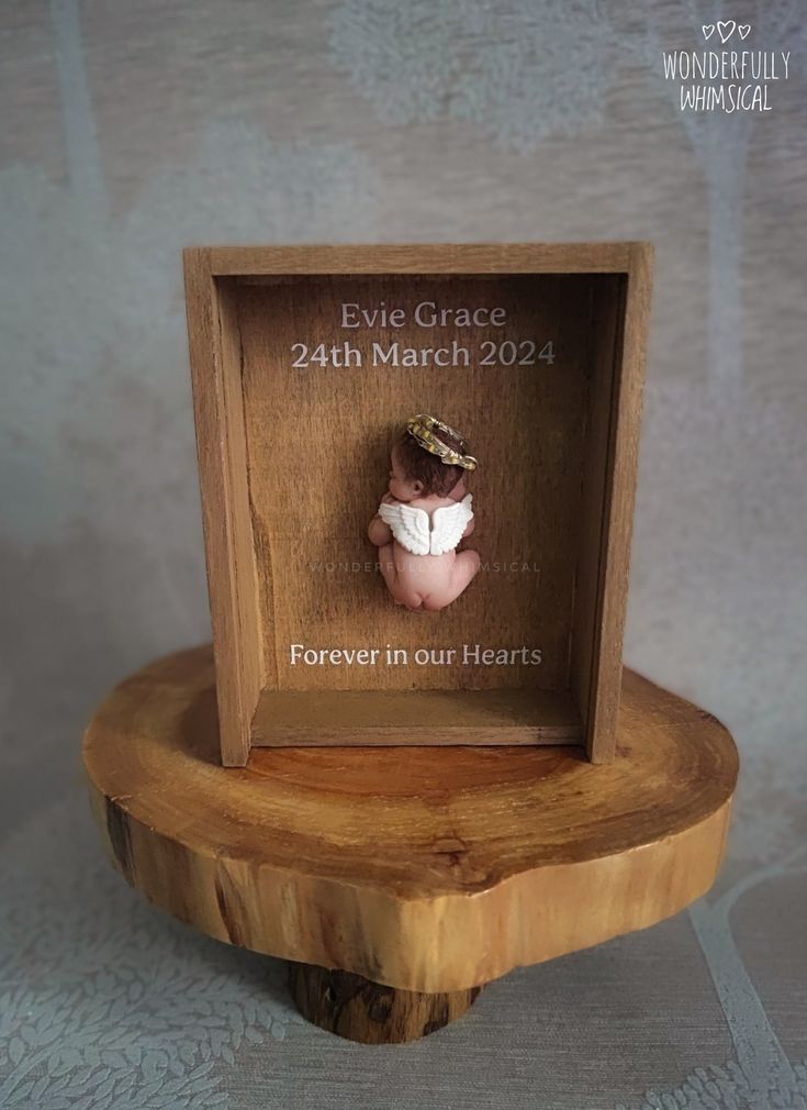 a small wooden frame with a baby's head in it on top of a table