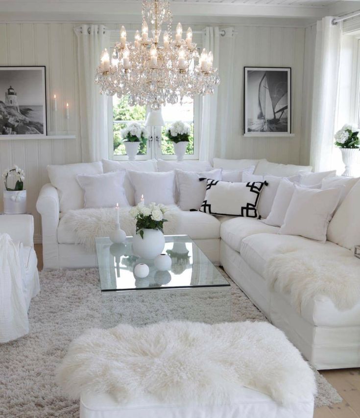 a living room with white furniture and chandelier hanging from the ceiling, on instagram