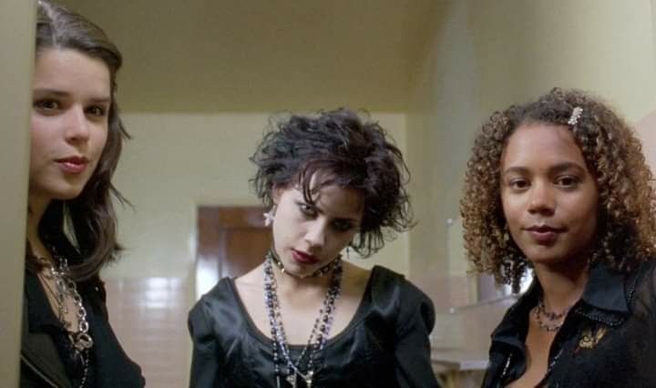 three young women standing next to each other in a hallway with one woman looking at the camera