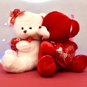 two teddy bears sitting next to each other with hearts on their chest and one holding the other