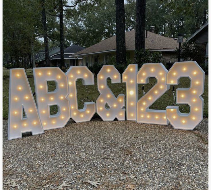 lighted letters spelling the word abc and s in front of a house