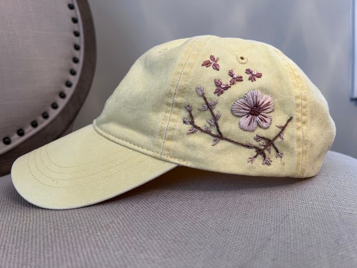 a baseball cap with embroidered flowers on it