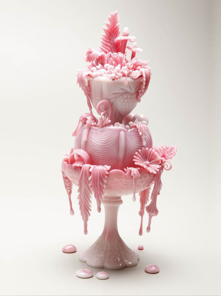 three tiered pink vases with white and pink flowers on them, all covered in icing