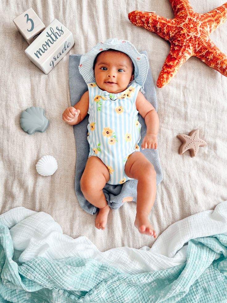 a baby laying on top of a bed next to a starfish