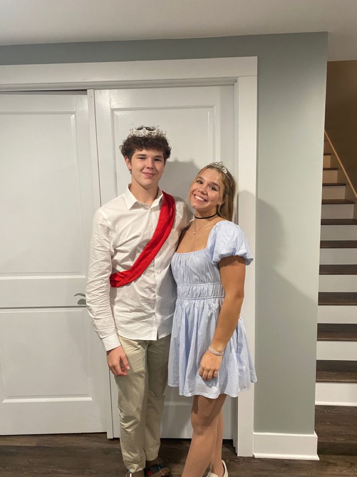 a young man and woman standing next to each other in front of a white door