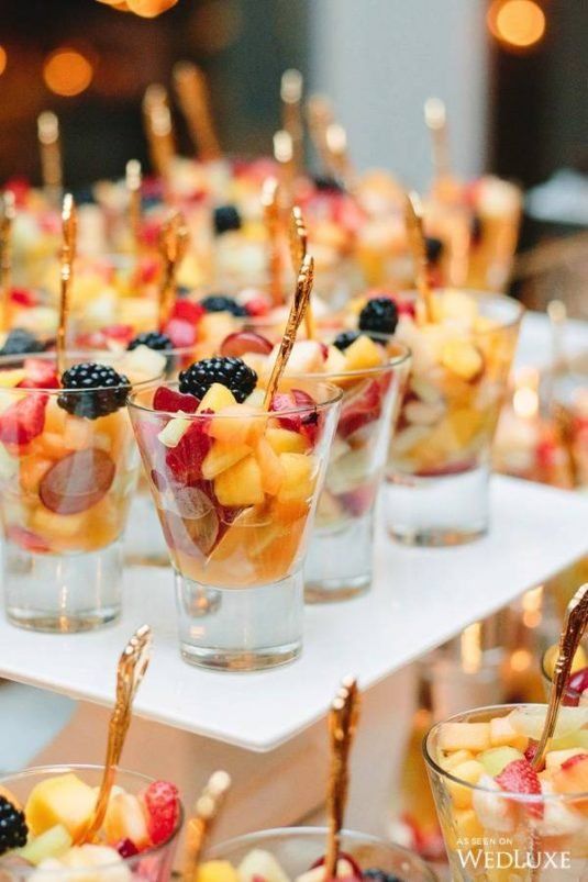 many small cups filled with fruit on top of a table