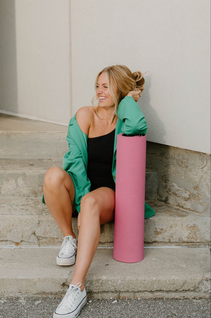 a woman sitting on the steps next to a pink tube