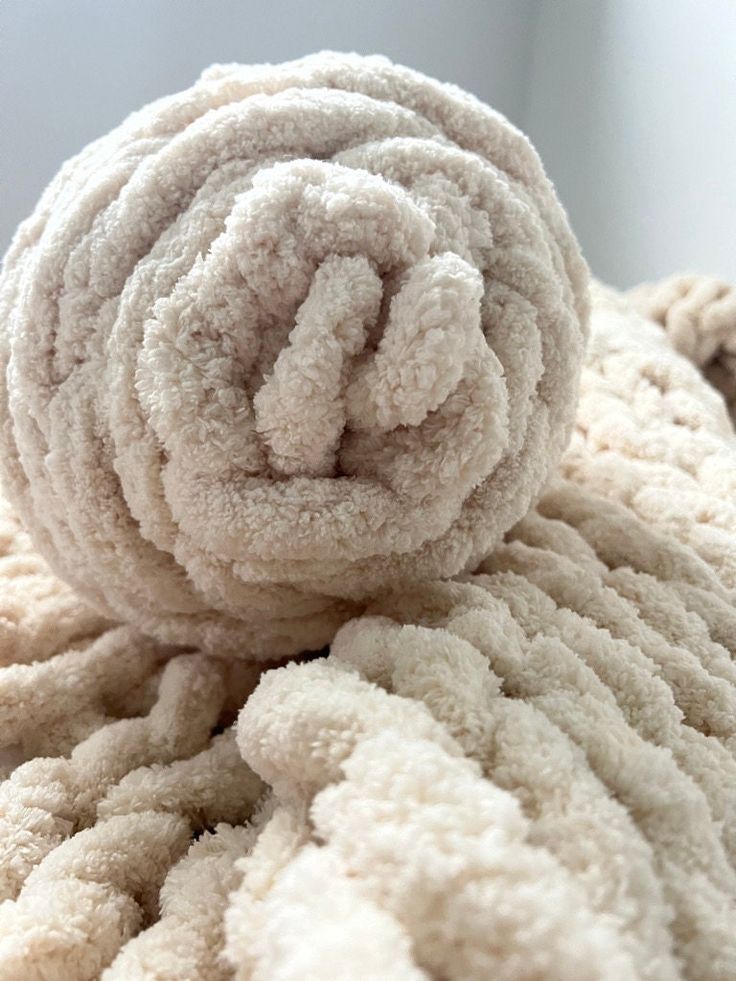 a pile of white towels sitting on top of a bed