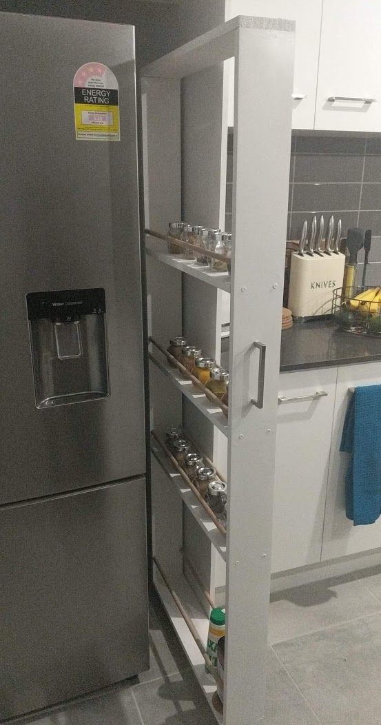 a stainless steel refrigerator in a kitchen next to a counter with food and drinks on it