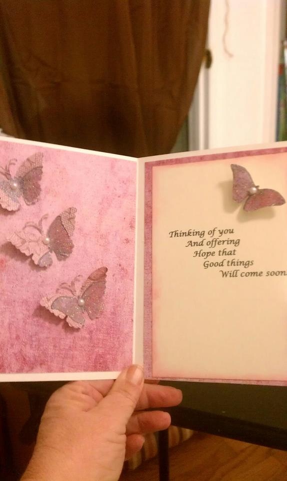 a hand holding an open card with butterflies on it