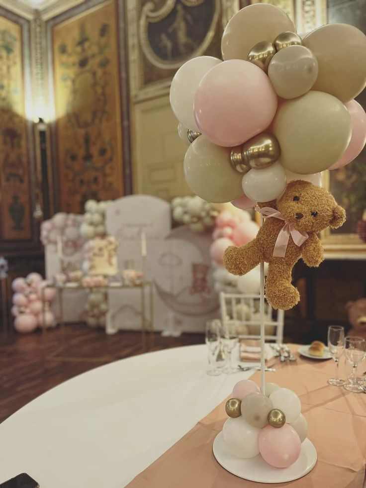 a teddy bear on a table with balloons