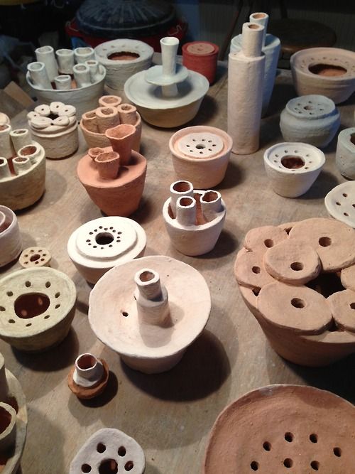 many different types of pottery sitting on a table