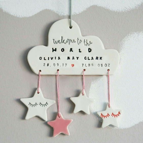 a wooden sign with stars hanging from it's side on the wall in front of a cloud