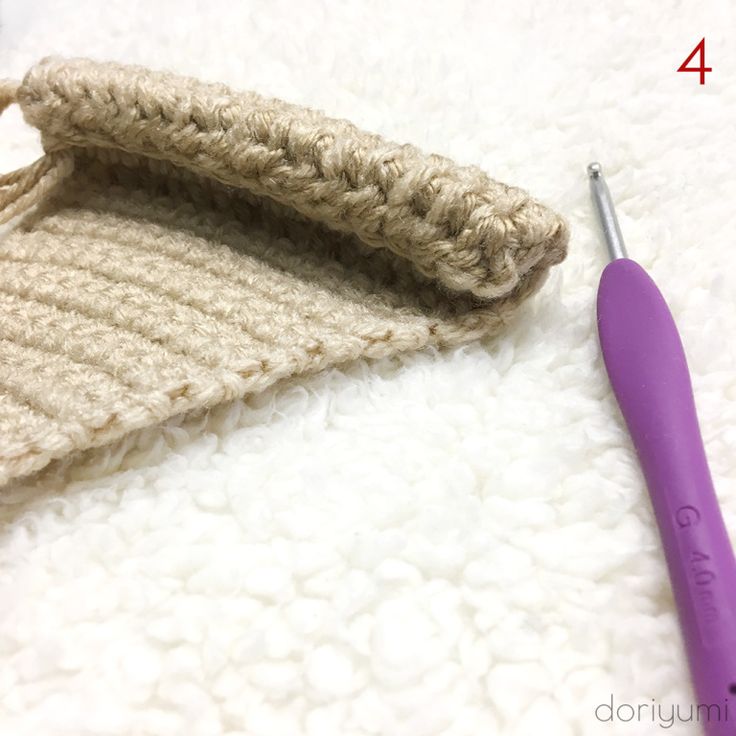 the crochet hook is next to a knitted object