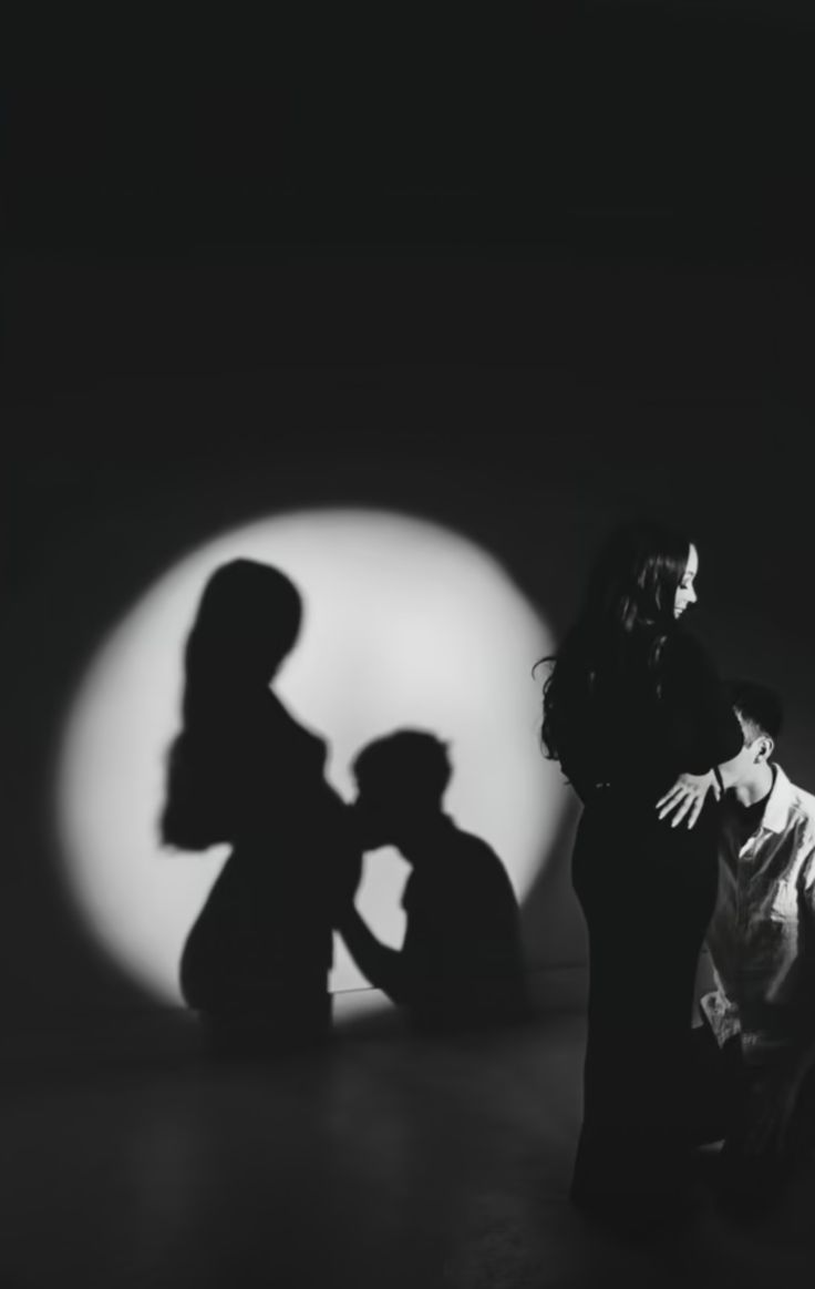 two people are standing in front of a shadow