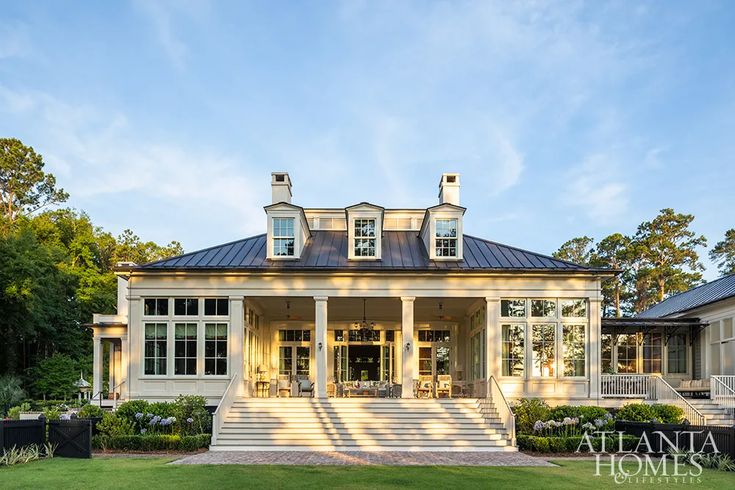 a large white house sitting on top of a lush green field