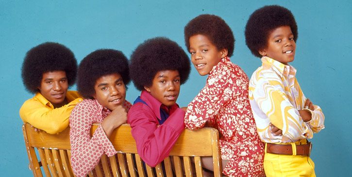 the jackson five sitting on a bench in front of a poster