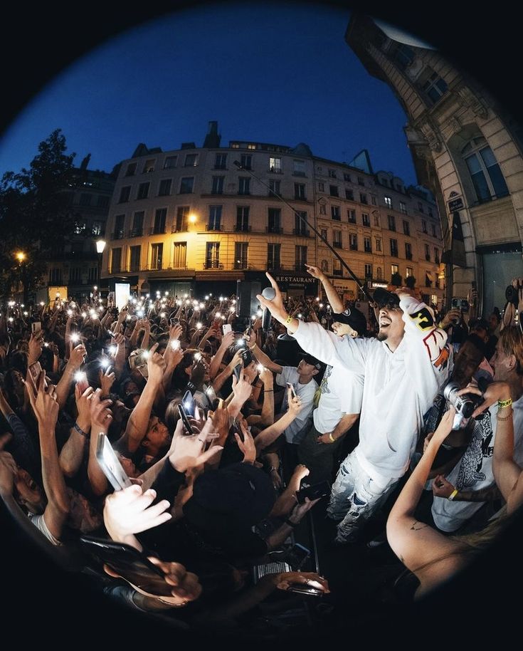 a crowd of people holding up their cell phones