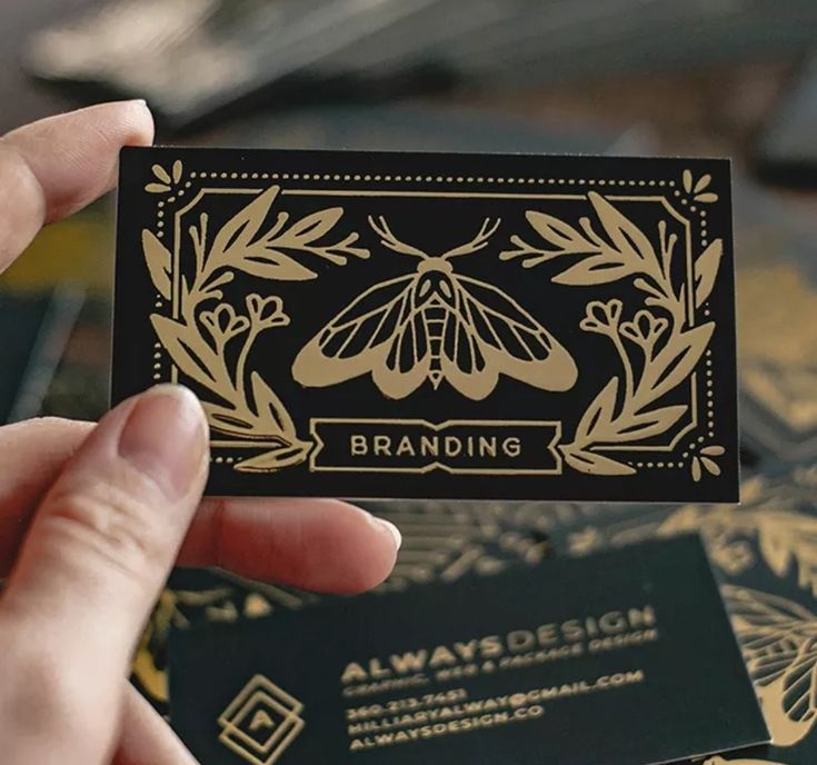 a person holding up a business card that says branding on the front and back