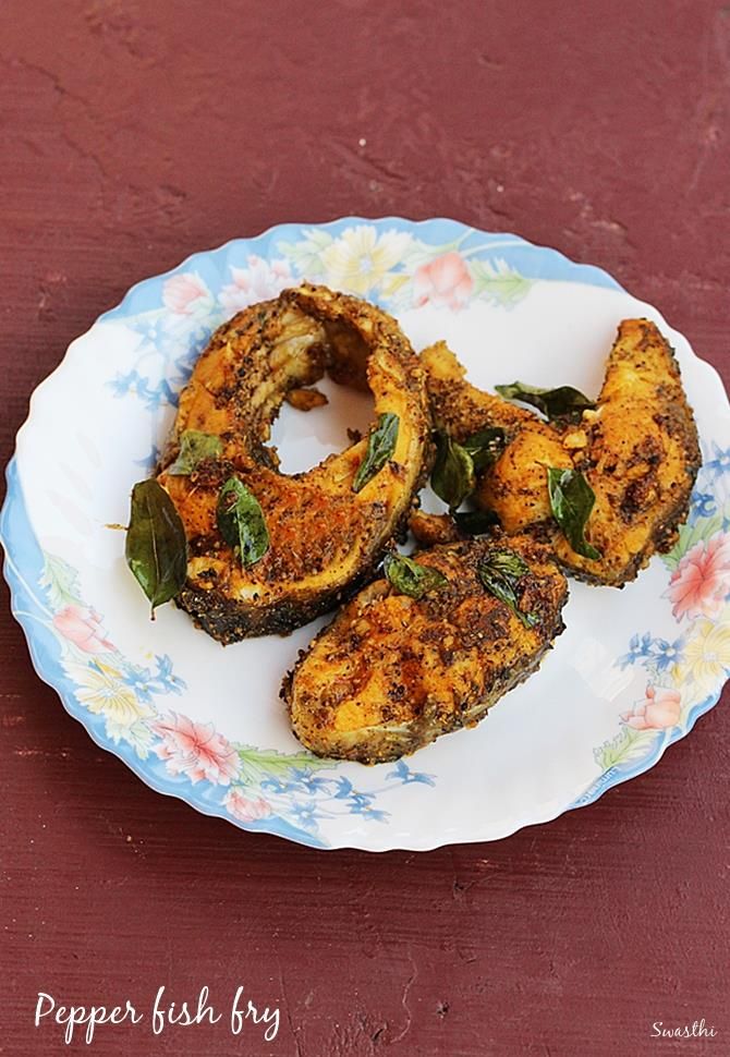 some fried food is sitting on a plate with flowers and leaves in the middle, ready to be eaten