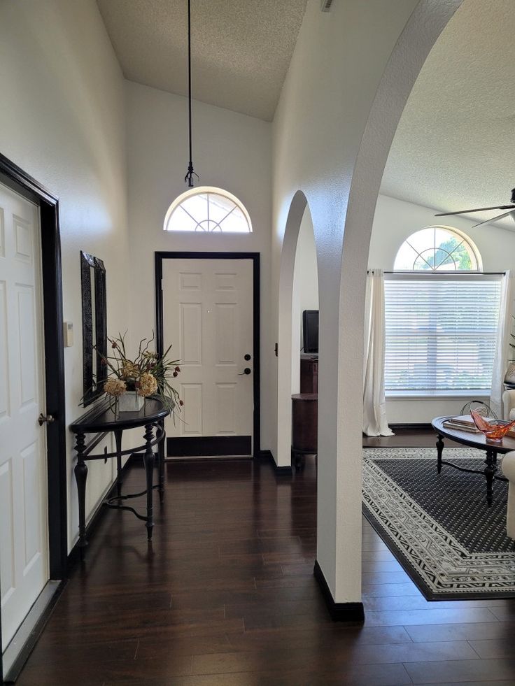 an archway leads to the living room and dining area in this home with hardwood floors