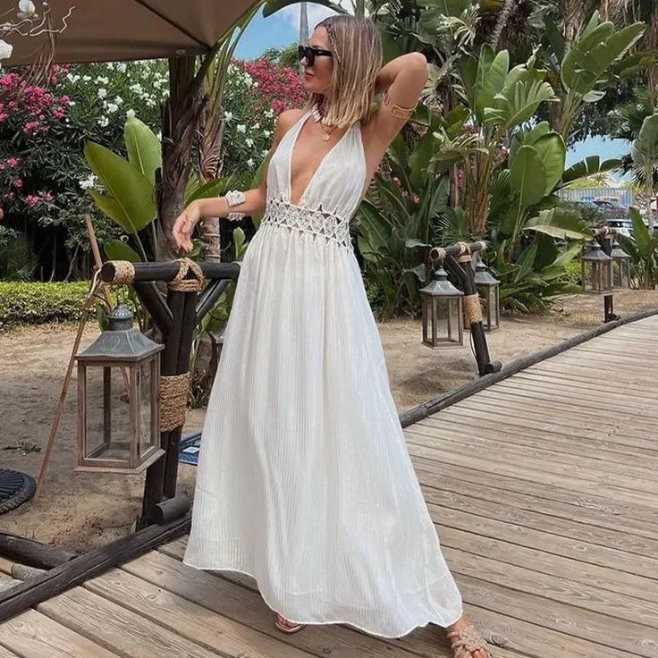 The Anneth Dress boasts a chic and elegant design with its backless halter style, embellished with delicate pearl sequins. Made from soft and breathable cotton material, this dress is perfect for warm weather. The sleeveless cut and high waist design add a touch of bohemian flair to your look. Sleeveless Backless Summer Wedding Dress, Chic Sleeveless Backless Dress For Beach Season, Elegant Backless Dress For Beach Season, Elegant Backless Dress For Beach Vacation, Elegant Sleeveless Backless Dress For Beach, Elegant V-neck Maxi Dress For Summer Parties, Chic Backless Dresses For Summer Parties, Summer Wedding Halter Neck Dress, Elegant Backless Party Beach Dress