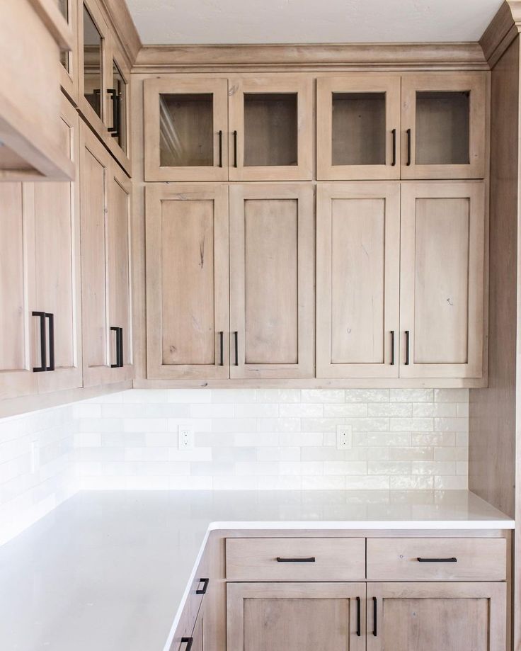 a kitchen with wooden cabinets and white counter tops