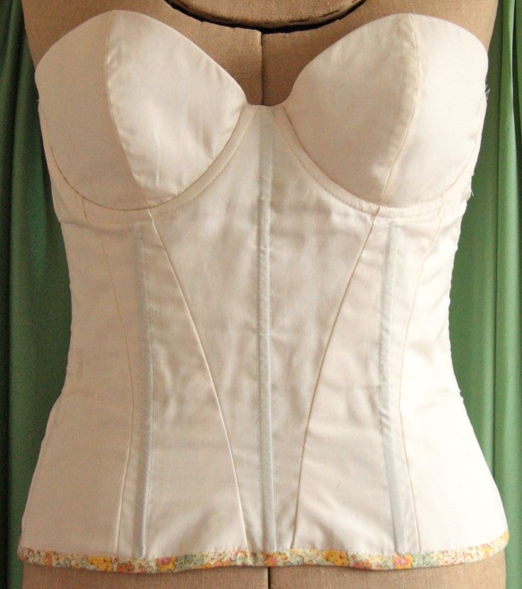 a white corset is displayed on a mannequin