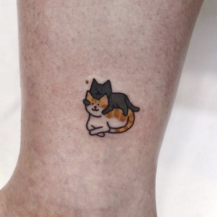 a small tattoo of a cat on the side of a person's leg,