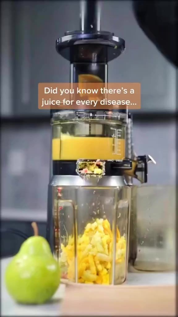 a juicer filled with lots of food next to an apple