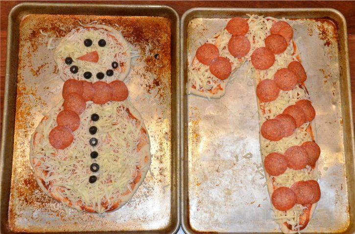 two pans with pizza shaped like snowmen