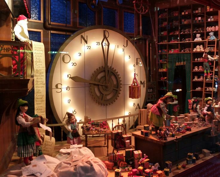 a large clock in the middle of a room filled with dolls and other items on display