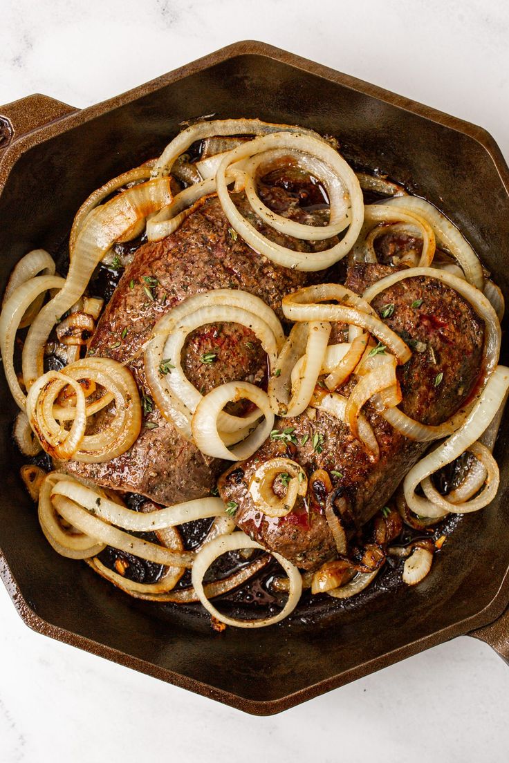 steak with onions and mushrooms in a skillet