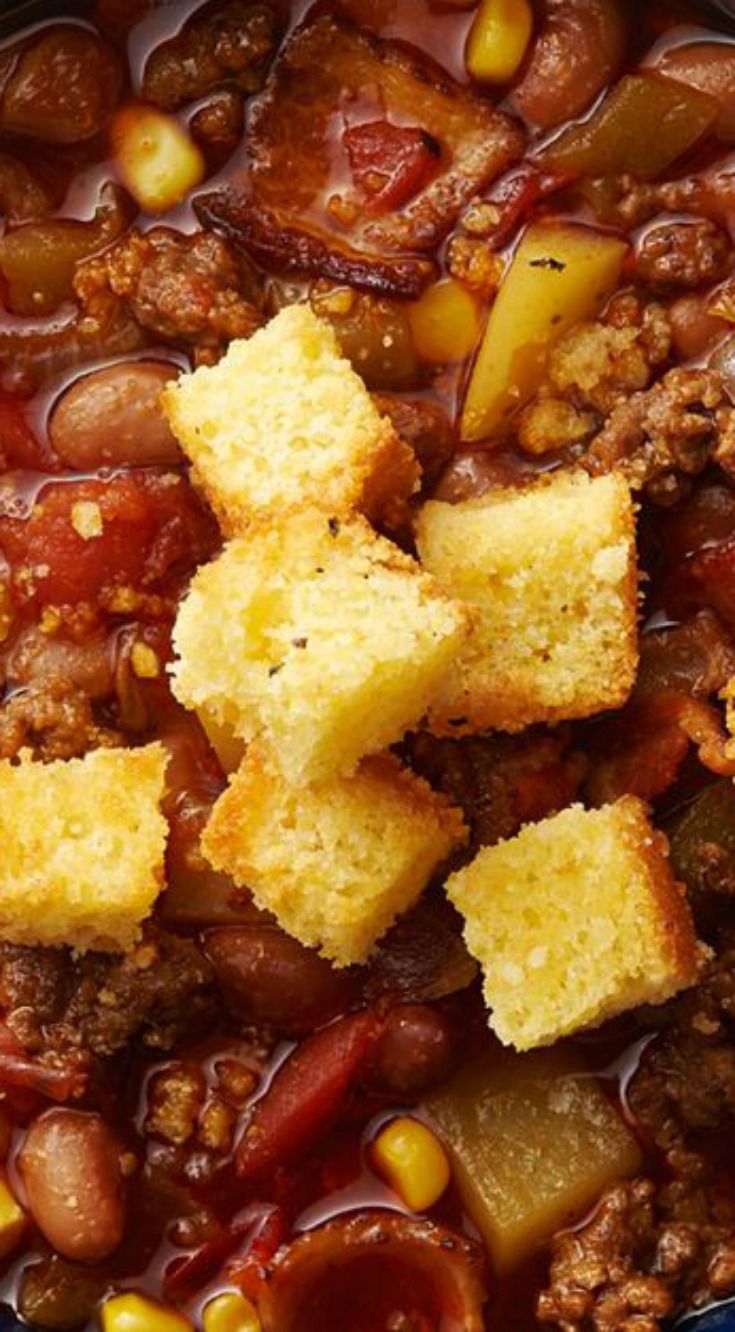 a bowl filled with chili and cornbread croutons