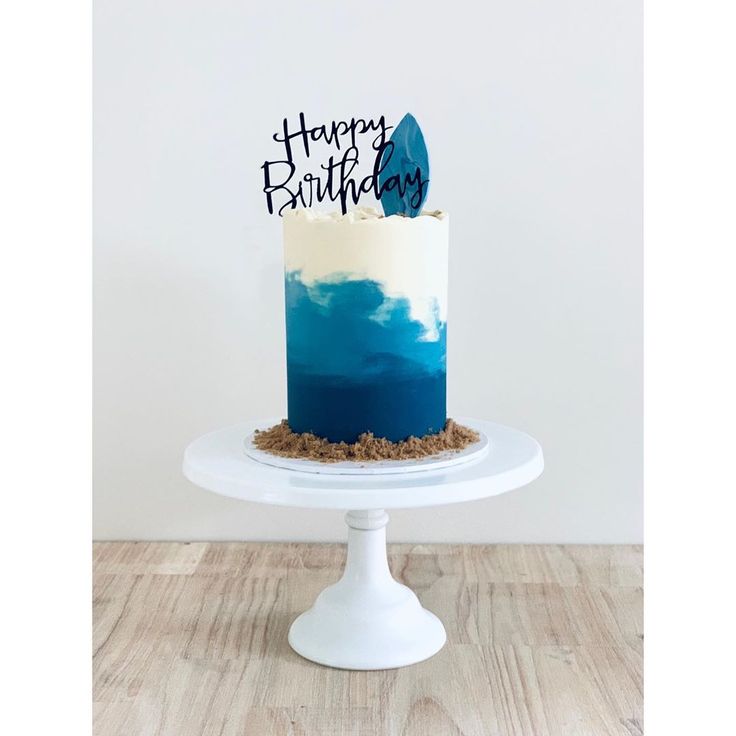 a blue and white birthday cake with the words happy birthday written on it's top