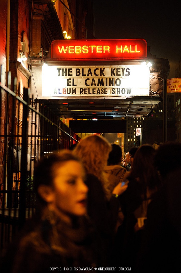 people are walking down the street in front of a theater sign that reads webster hall